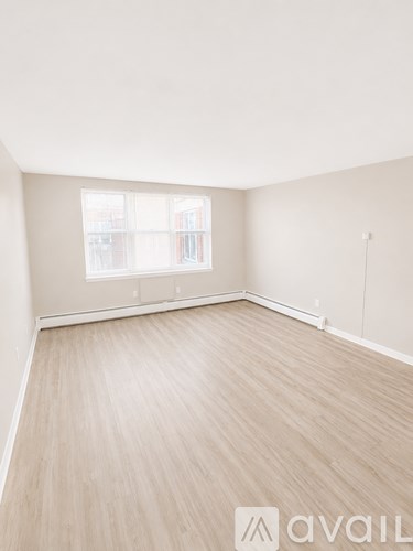 A room with wooden flooring and a window.