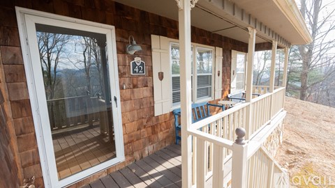 A house number 42 with a porch and a view of the trees.