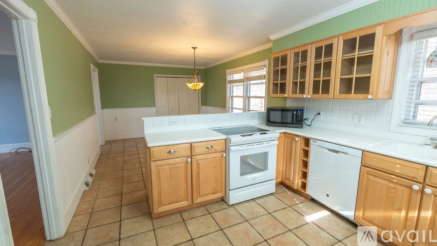 A kitchen with green walls and wooden cabinets is available.