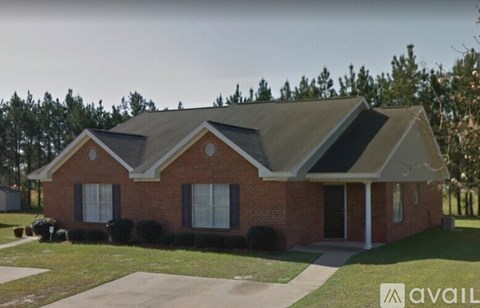 A red brick house with a black roof and a white door.