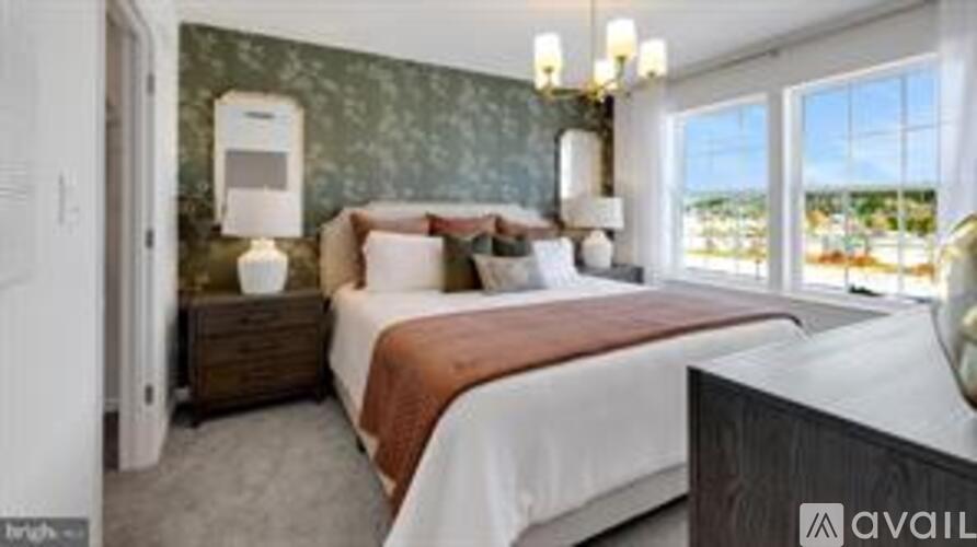 A bedroom with a large bed and a chandelier.