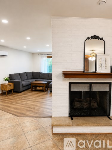 A living room with a grey couch and a fireplace.