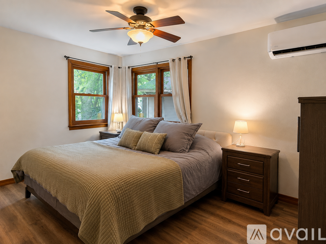 A bedroom with a bed, nightstand, and window.