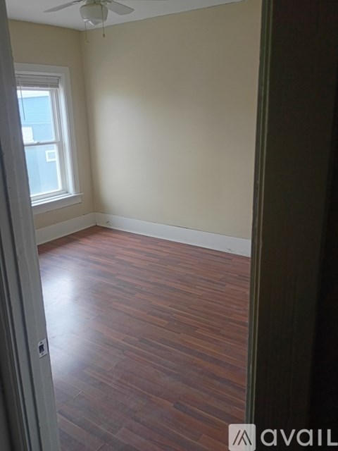 A room with wooden flooring and a window.