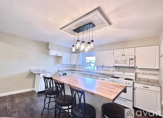 A kitchen with a wooden island and white cabinets.