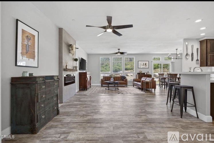 A spacious kitchen and dining area with dark wood flooring and modern appliances.