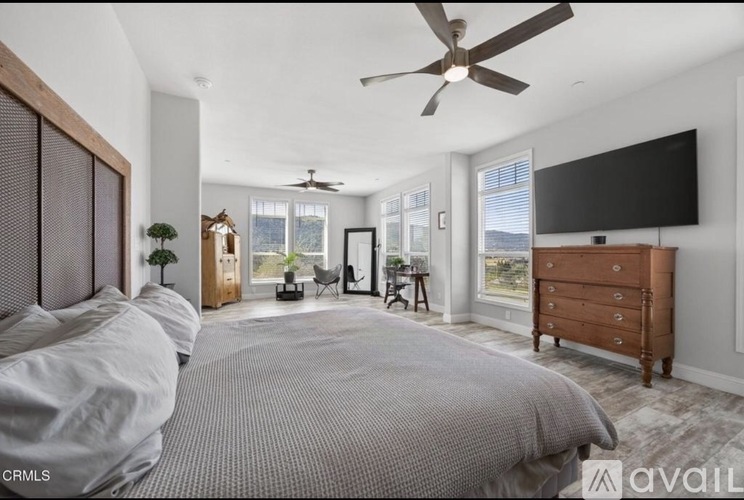 A bedroom with a large bed and a ceiling fan.
