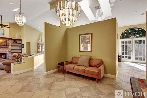 A living room with a couch, a fireplace, and a painting on the wall.