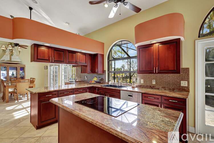 A kitchen with a marble countertop and wooden cabinets.
