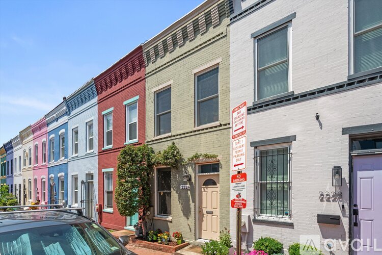 A row of houses with a car parked in front of them.