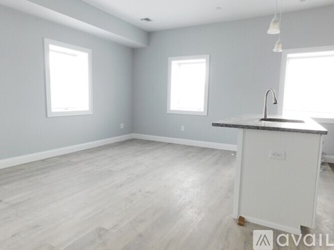 A spacious kitchen with a white island and wooden flooring.