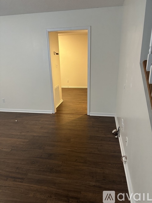 A room with a white door and wooden floor.