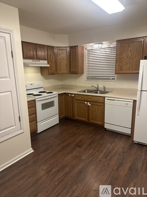 A kitchen with wooden cabinets and white appliances.