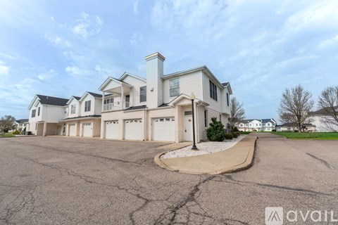 A large, modern house with a driveway in front.