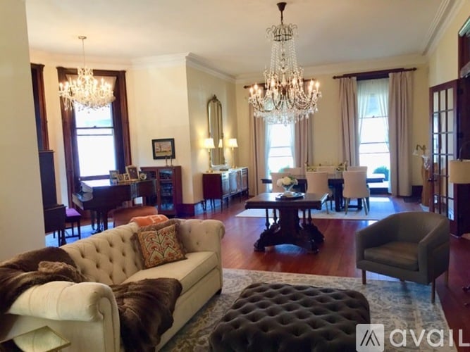 A living room with a white couch and a chandelier.