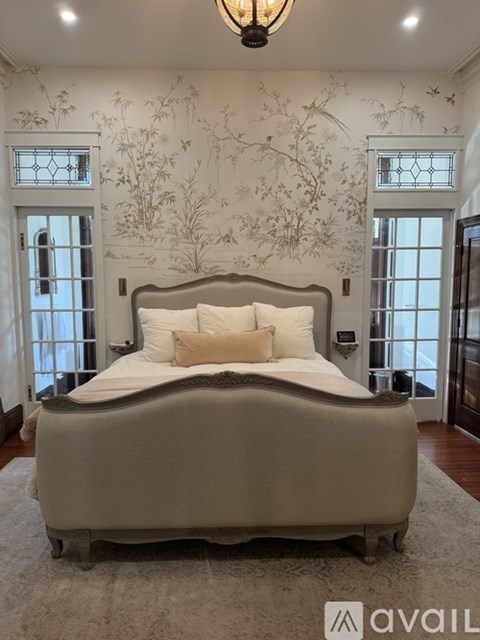A bedroom with a large bed and a wallpapered wall.