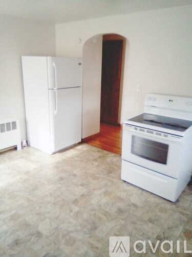 A white fridge and oven in a kitchen with a tiled floor.