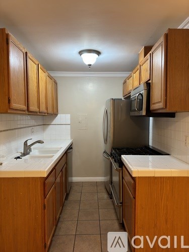 A kitchen with wooden cabinets and a refrigerator.