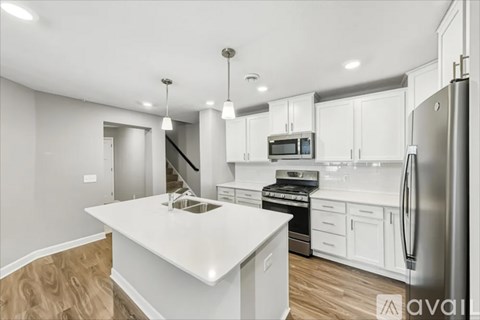 A modern kitchen with white cabinets and a wooden island.