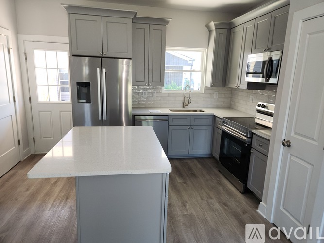 A kitchen with a white countertop and stainless steel appliances.