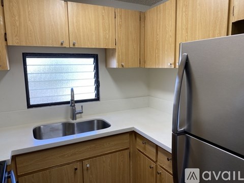 A kitchen with wooden cabinets and a stainless steel refrigerator.