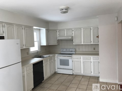 A kitchen with white appliances and cabinets.