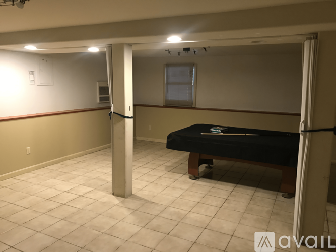 A room with a pool table and a window.