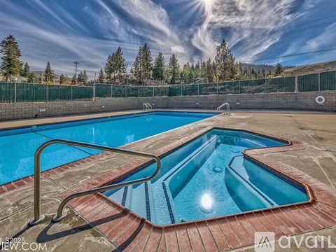A swimming pool with a metal ladder and steps leading into the water.