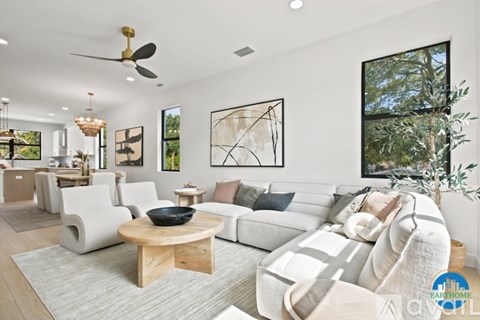A modern living room with a white sofa set and a wooden coffee table.