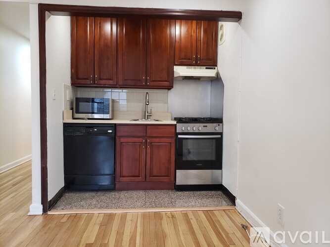A kitchen with wooden cabinets and a black dishwasher.