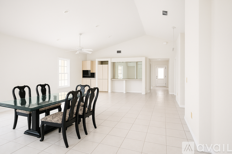 A spacious dining room with a glass table and chairs.