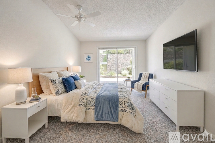 A bedroom with a bed, nightstand, and chair.