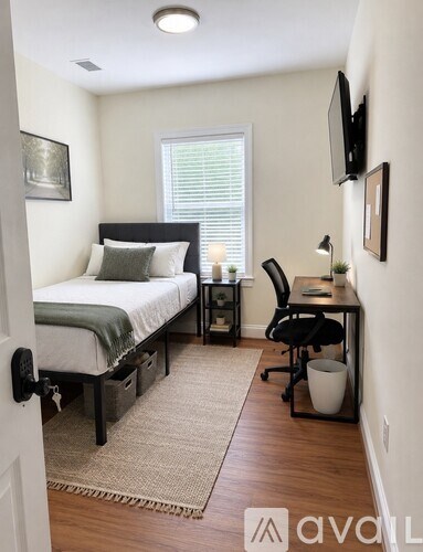 A bedroom with a bed, desk, and chair.