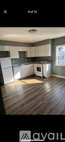 A kitchen with wooden floors and white appliances.