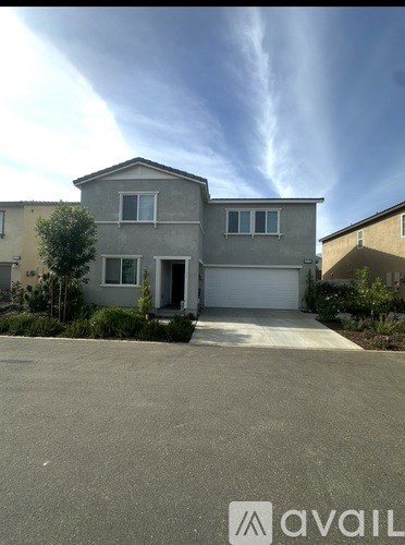 A house with a grey roof and a white garage door is for sale.
