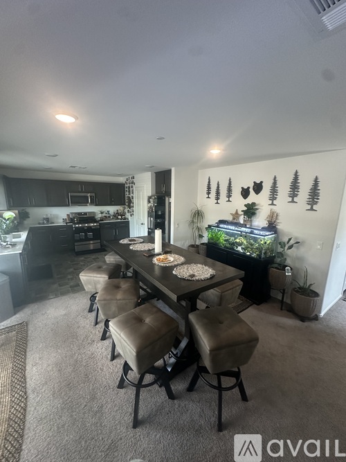 A dining area with a table set for six and a fish tank on the wall.