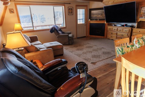 A living room with a black leather chair in the foreground.