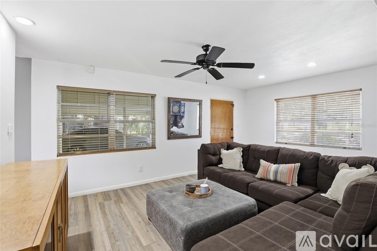 A living room with a brown couch and a wooden table.