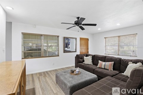 A living room with a brown couch and a wooden table.