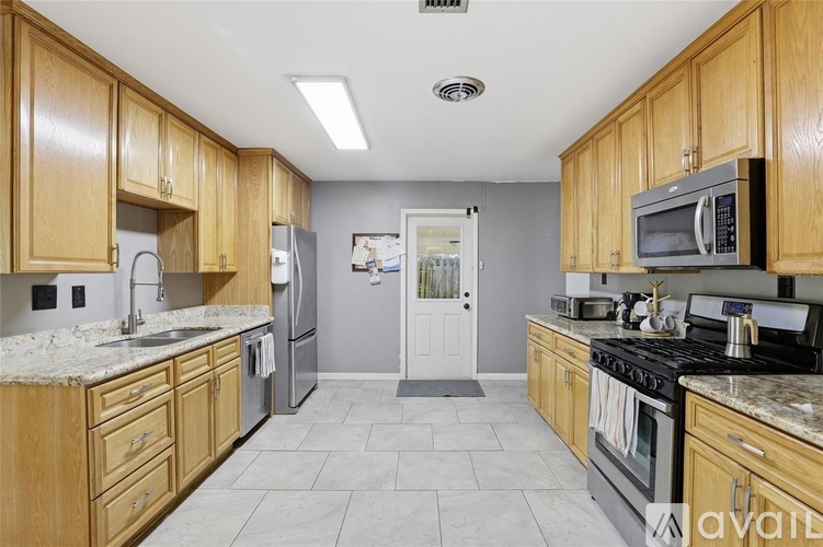 A kitchen with wooden cabinets and granite countertops.