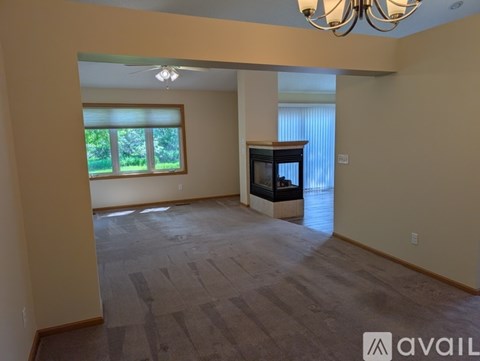 A spacious living room with a television and a ceiling fan.