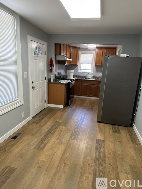 A kitchen with wooden floors and a refrigerator.