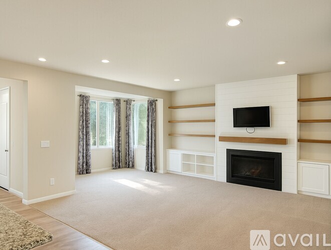 A spacious living room with a fireplace and a television.