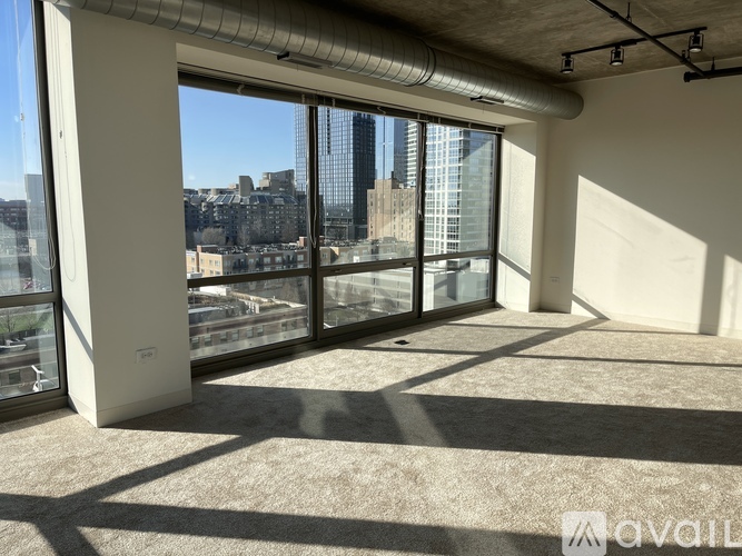 A spacious room with large windows overlooking a cityscape.