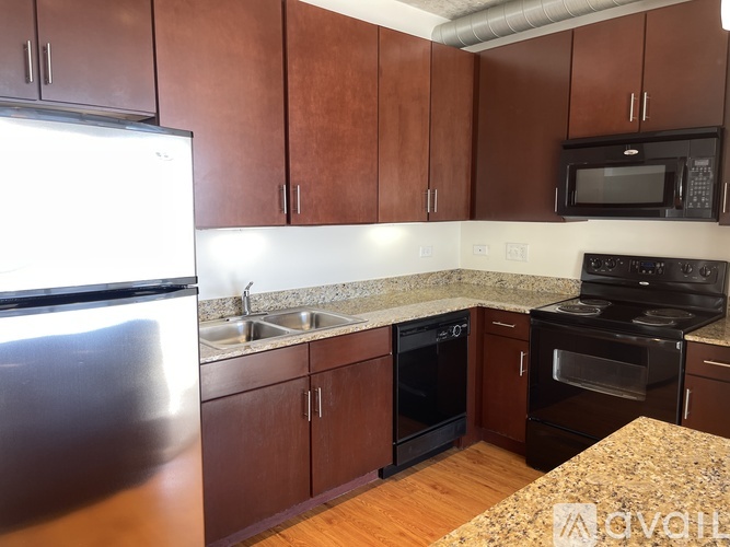 A kitchen with brown cabinets and a granite countertop.