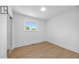 A room with a window showing trees outside.