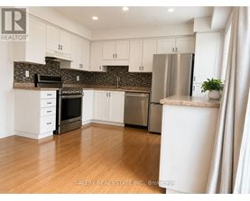 A kitchen with white cabinets and a stainless steel refrigerator.