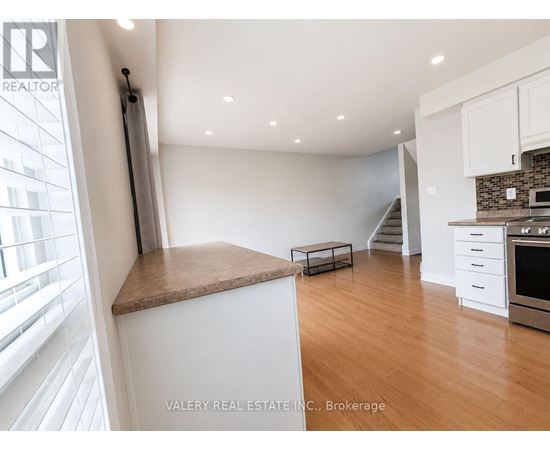 A kitchen with white cabinets and a brown countertop.