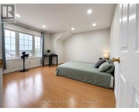 A bedroom with a bed, a table, and a window.