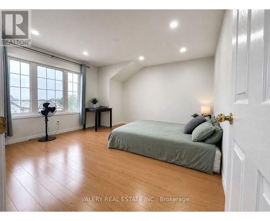 A bedroom with a bed, a table, and a window.